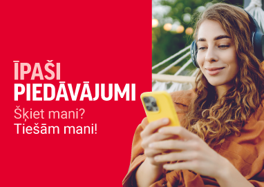 Sieviete ar austiņām ārā guļ šūpuļtīklā un skatās telefonā. 