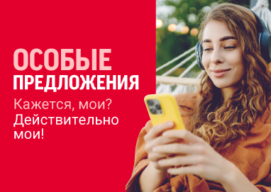 Женщина с наушниками лежит в гамаке и смотрит в телефон. 