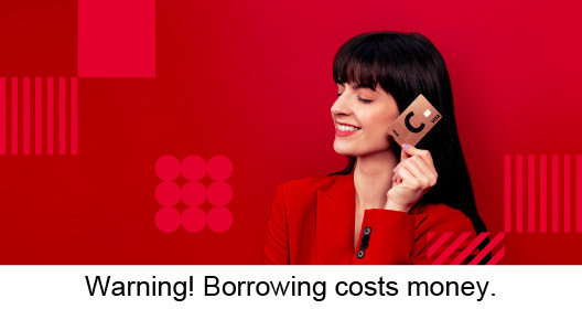 A girl in red clothes holds a lava-coloured Citadele C prime card in her left hand. Warning! Borrowing costs money.