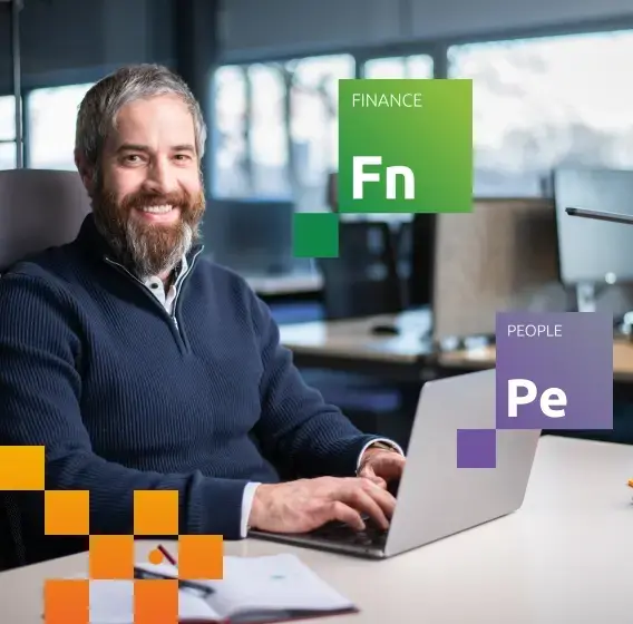 Человек за ноутбуком в офисе с цветными графическими элементами.